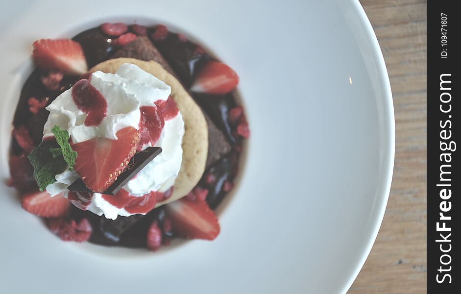 Top view of Chocolate brownie with vanilla favor ice cream on top serve on the white plate