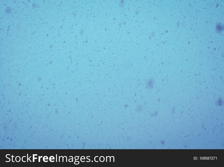 Fresh falling snow over grey sky close up background. Fresh falling snow over grey sky close up background.