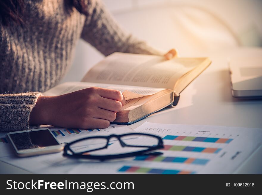 Focus hand open book for reading on desk work with gold lighting at the morning