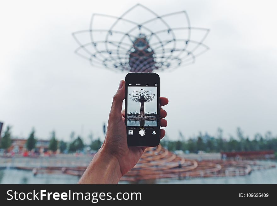 Person Taking Photo Of Tower