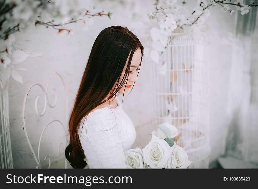 Woman Wearing Wedding Dress Holding Bouquet of Flower