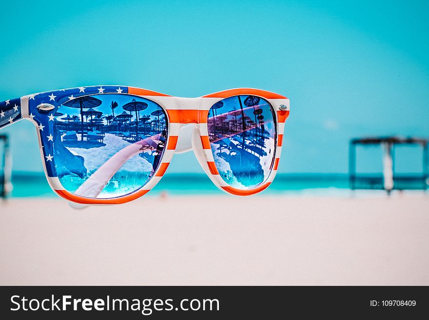 Focus Photography of American Flag-accent Wayfarer-styled Sunglasses With Sea Background