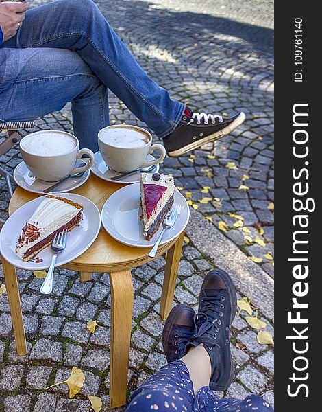 Street cafe in Weimar, Germany. Two cups of coffee latte and a pieces of cake