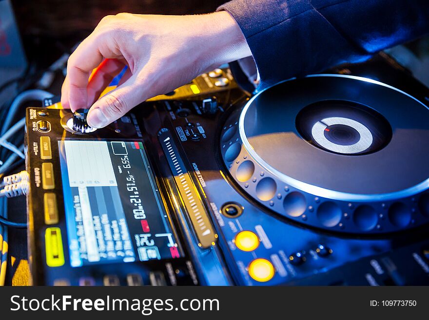 Dj mixes the track in the nightclub at party. Dj mixes the track in the nightclub at party