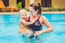 Young Mother Teach Her Little Son, How To Swim In A Swimming Pool Royalty Free Stock Image