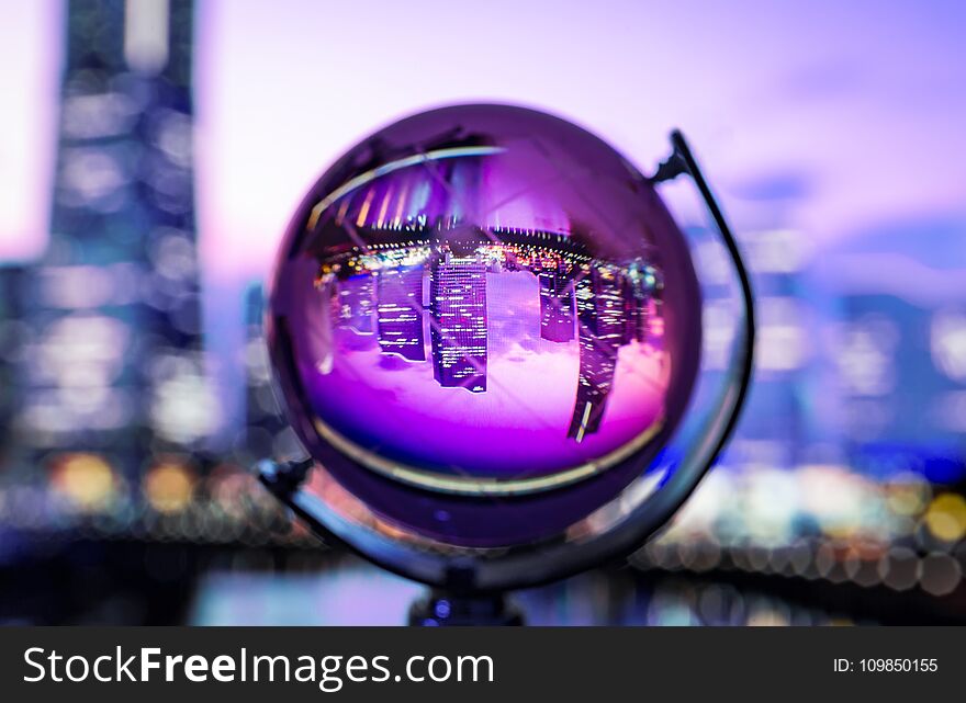 Crystal globe with blur background and reflection of cityscape inside. Crystal globe with blur background and reflection of cityscape inside