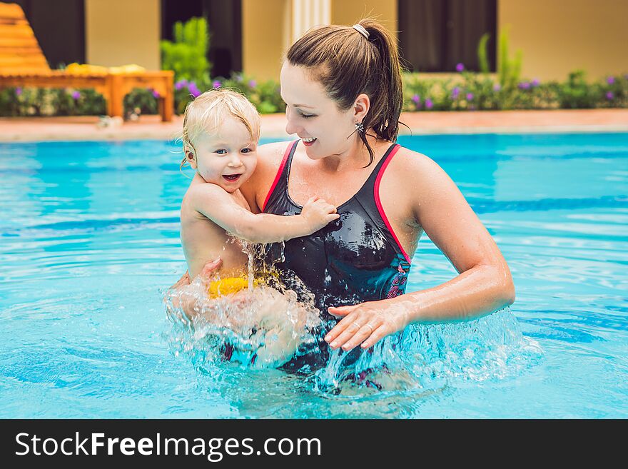 Young Mother Teach Her Little Son, How To Swim In A Swimming Pool