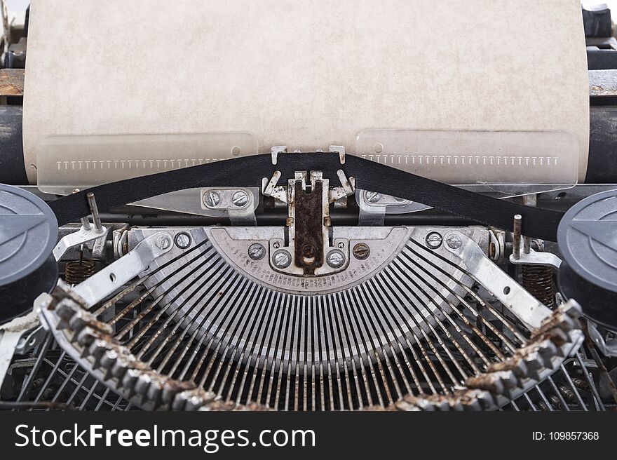 Blank sheet of paper inserted into the vintage typewriter for typing. Blank sheet of paper inserted into the vintage typewriter for typing