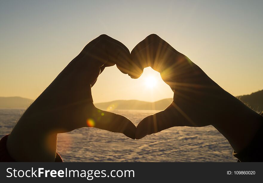 Young Man And Woman Making A Heart Shape With Her Fingers.