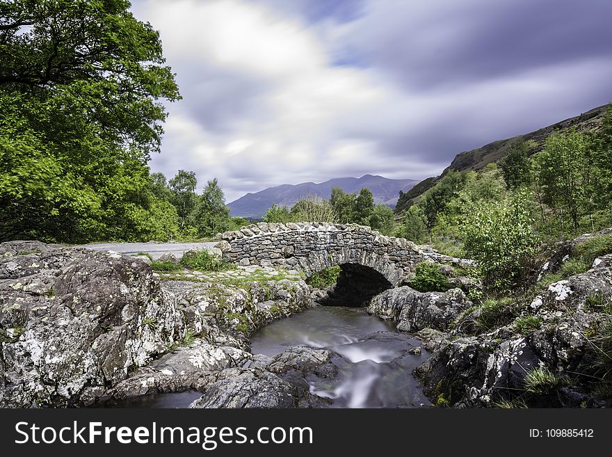 Gray Rock Formation Near Water Falls Under Cloudy Sky