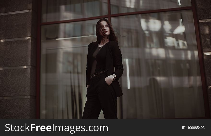 Woman Standing Near Clear Glass Window