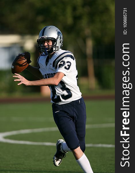 Man In White And Black Football Jersey Playing On Field During Daytime