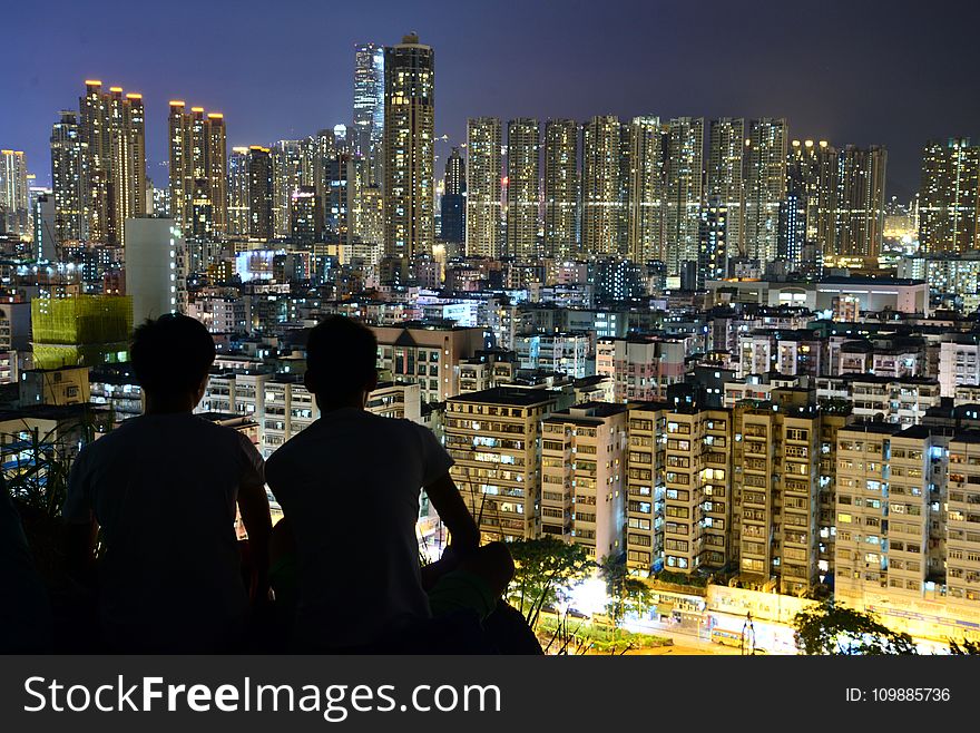 Silhouette of 2 Person on Top of the Building during Nighttime
