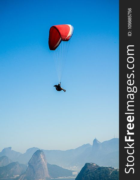 Red White Parachute on Top of Mountains during Daytime