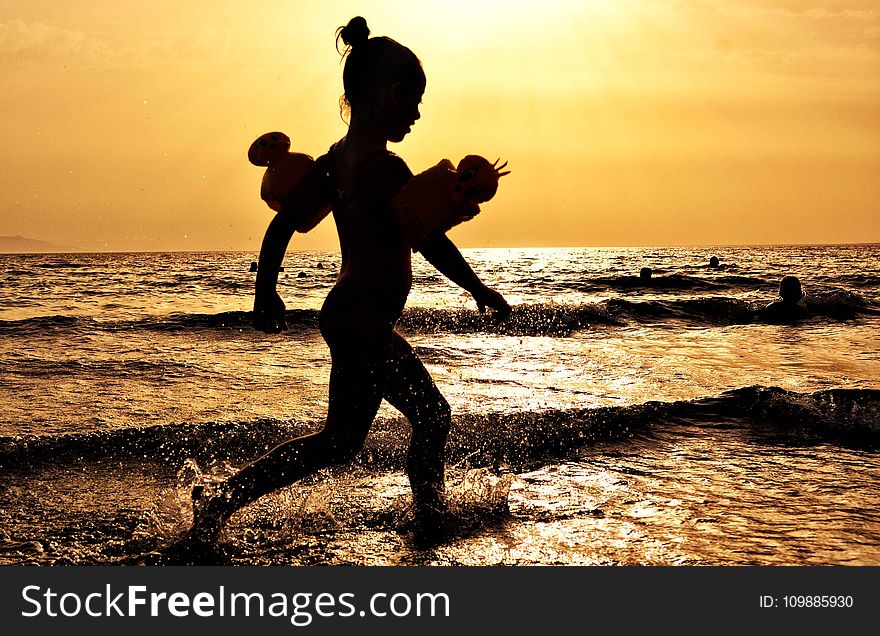 Silhouette of Girl Running on the Seashore during Golden Hour