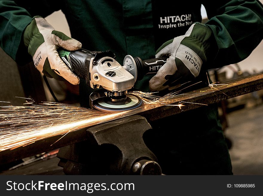 Person Holding Black and Gray Hitachi Angle Grinder