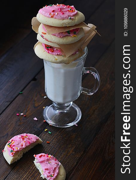 Cookies With Pink Cream on Top of Clear Short Stem Footed Mug With Milk