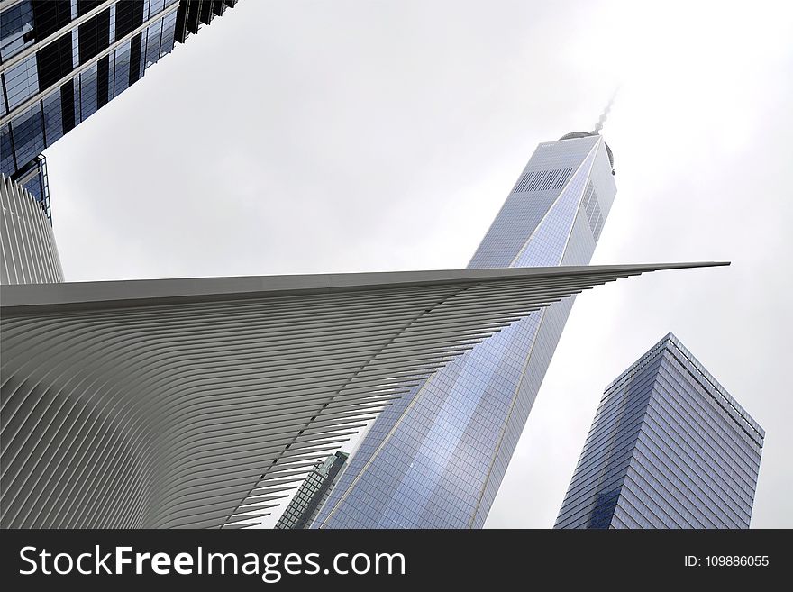 White Concrete Tower Shape Building Near Building During Daytime