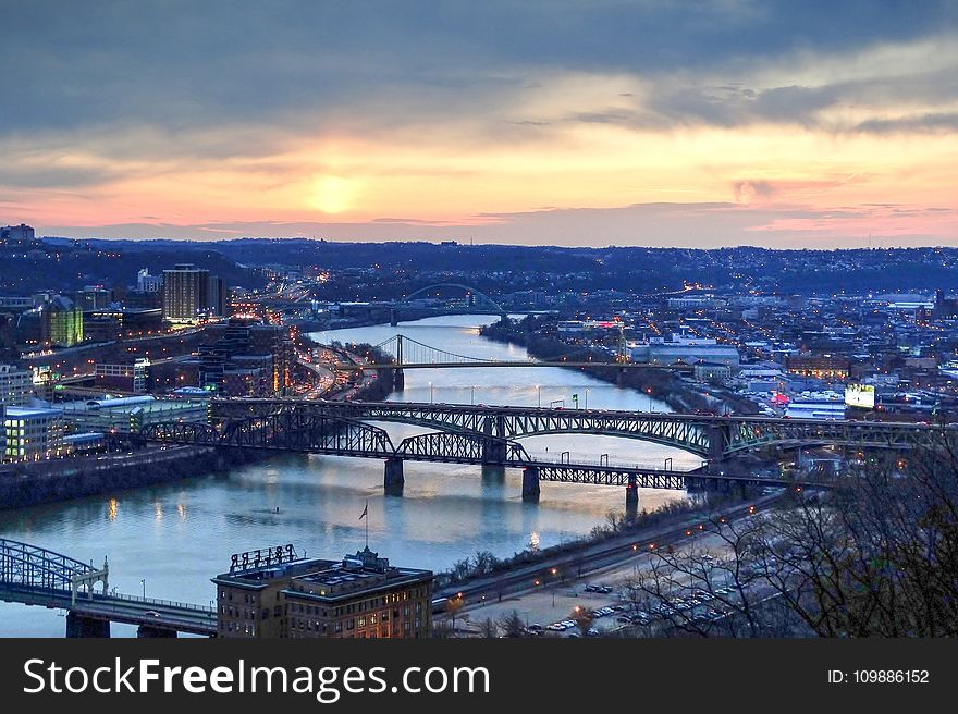 Panorama View Of Suspension Bridge Connecting Urban City During Golden Hour