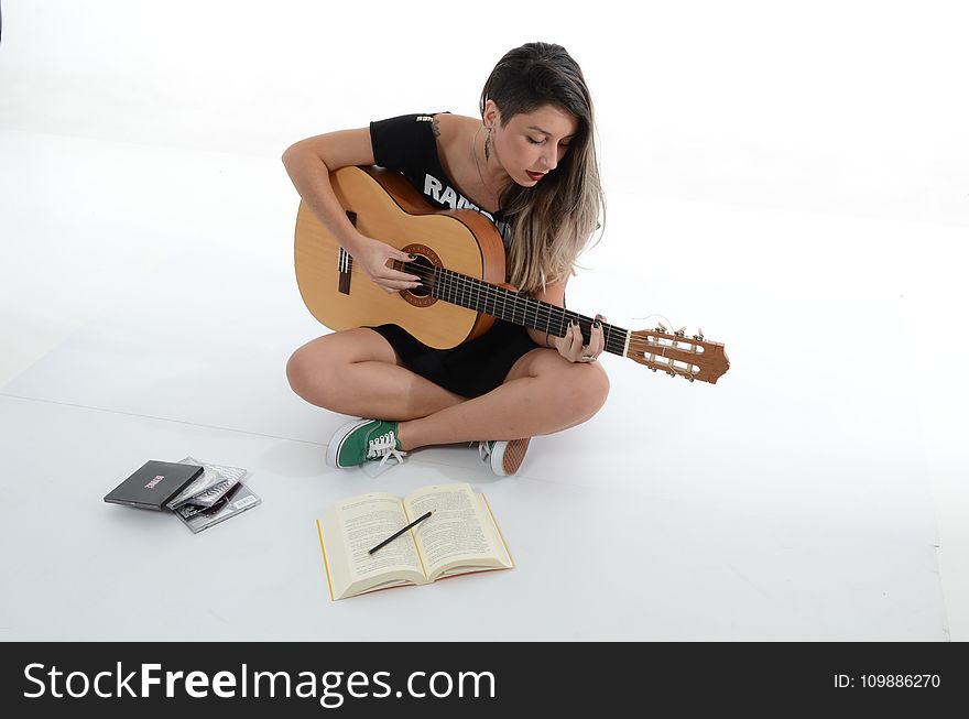 Woman Playing Brown Classical Guitar