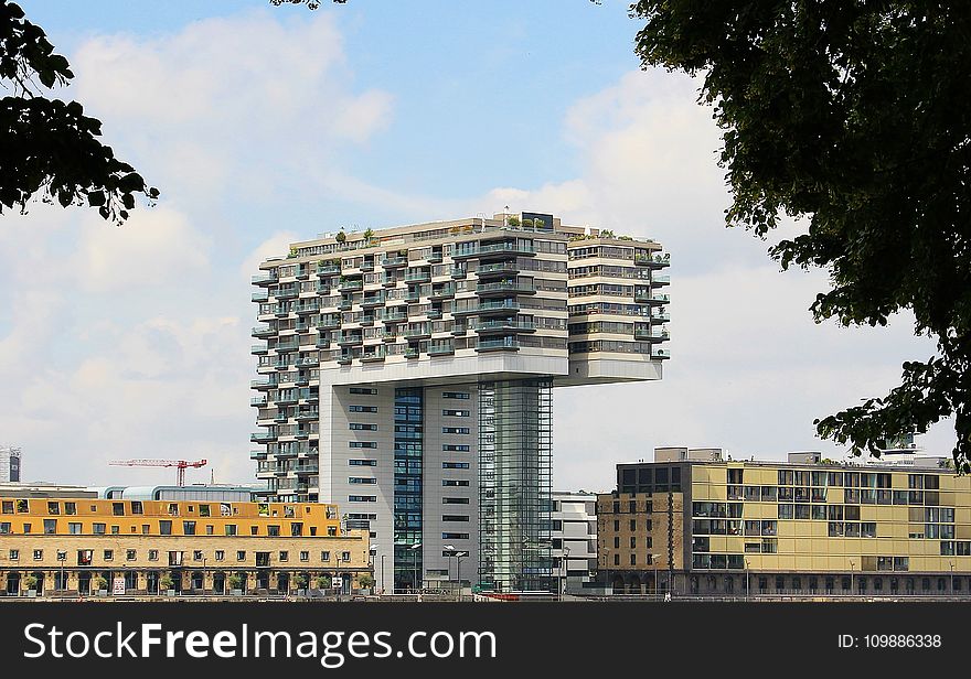 White and Gray Concrete Building Under Cloudy Blue Sky during Daytime