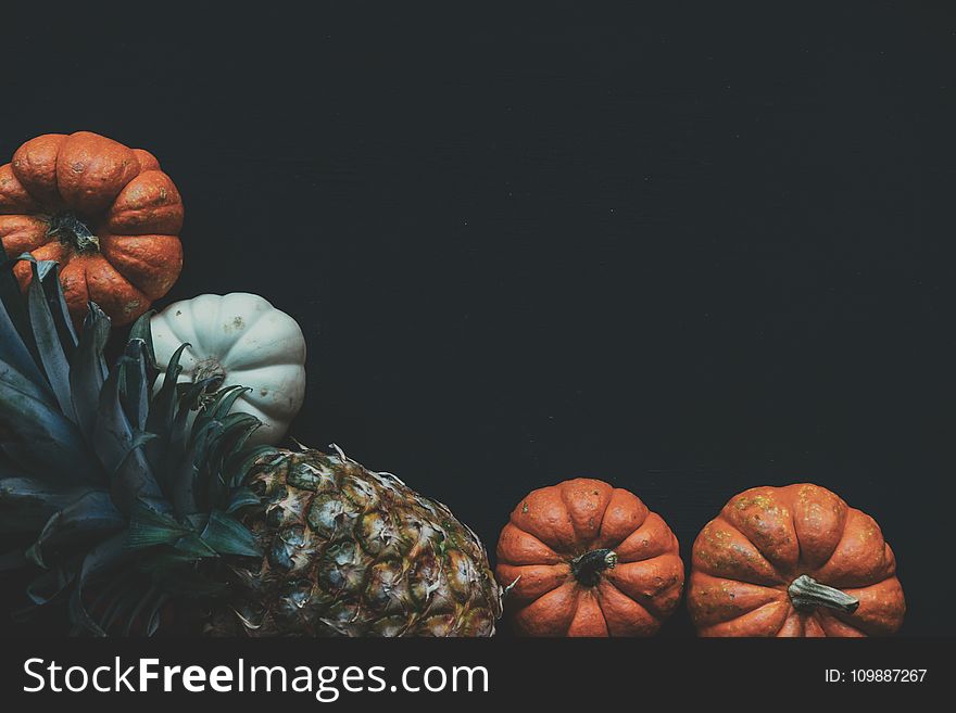 Photography of a Pineapple Fruit Near Two Squashes