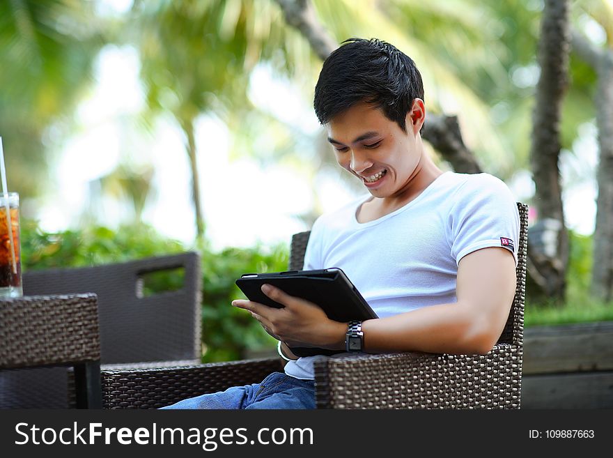 Man In White Shirt Using Tablet Computer Shallow Focus Photography