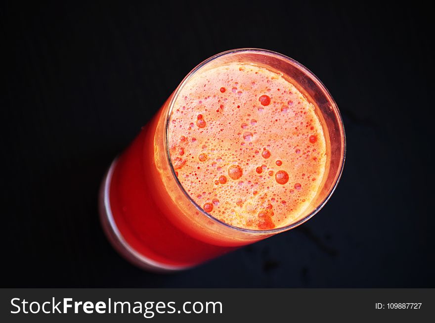 Glass of Orange Liquid in Close Up Photography