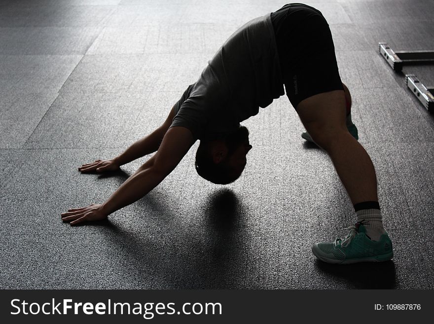 Man in Grey Shirt Doing Yoga on Gray Ceramic Tile Floor