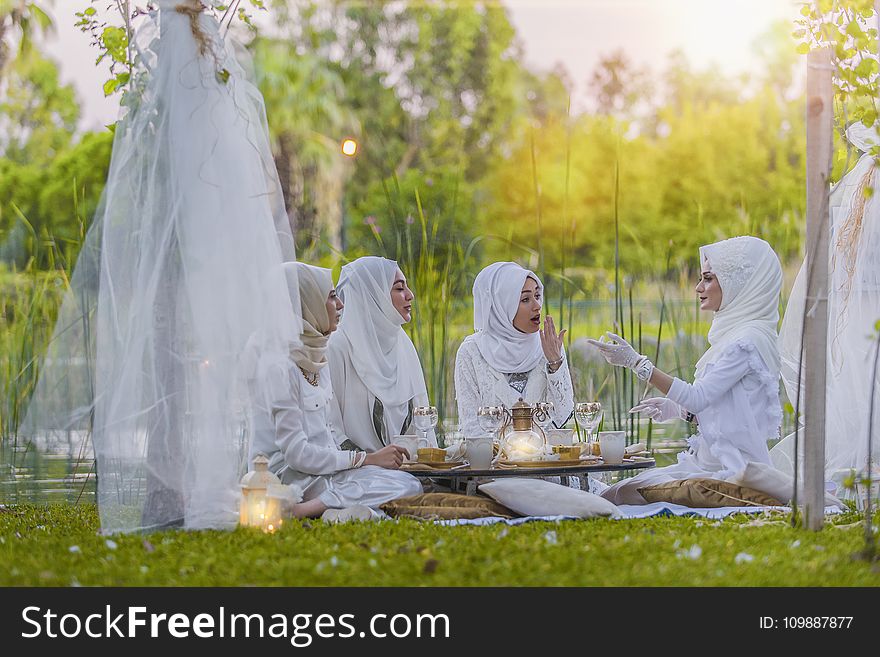 4 Women in White Abaya Wedding Gown Having Picnic Near Trees