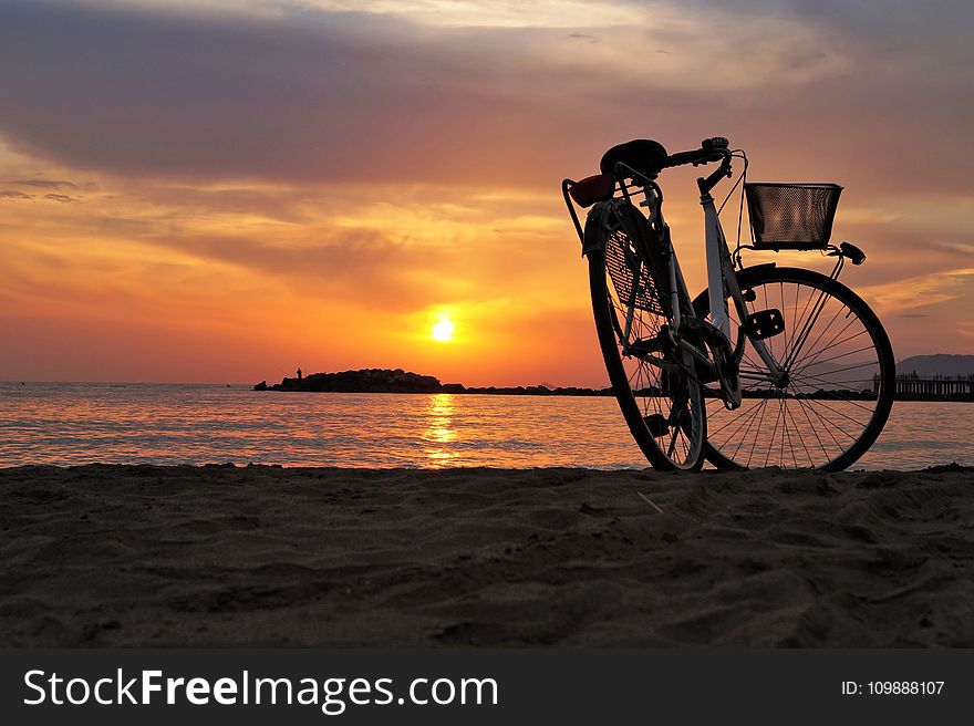 White Hard Tail Bicycle On Brown Beach Sand During Sunsets