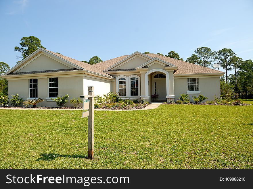 White And Brown Concrete Bungalow Under Clear Blue Sky