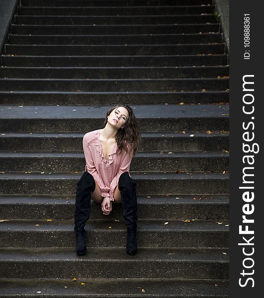 Woman In Pink Dress Shirt Sitting On Stares