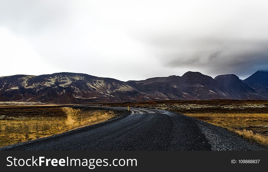 Curve Road Near Mountains during Daytime