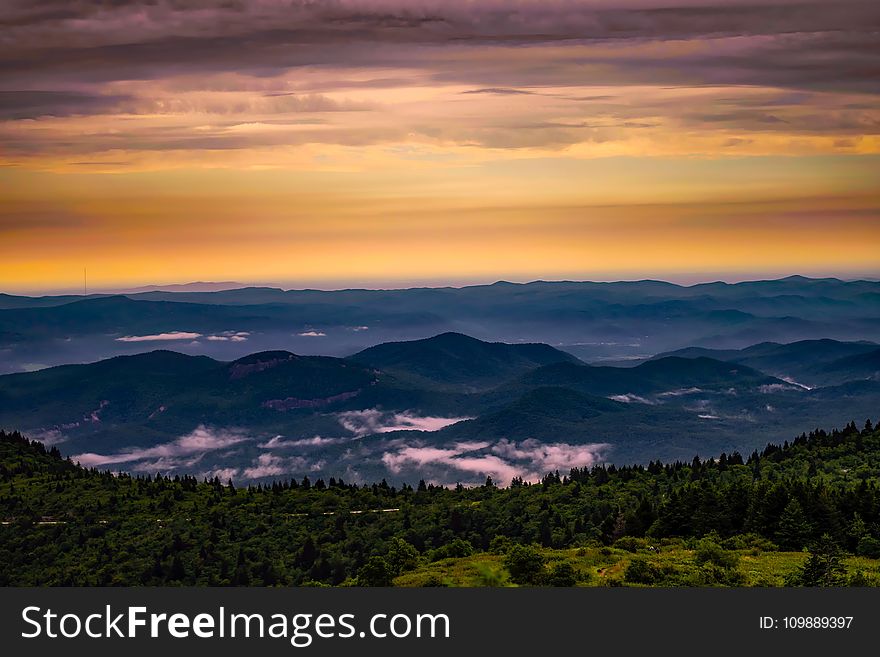 Scenic View Of Mountains Against Cloudy Sky