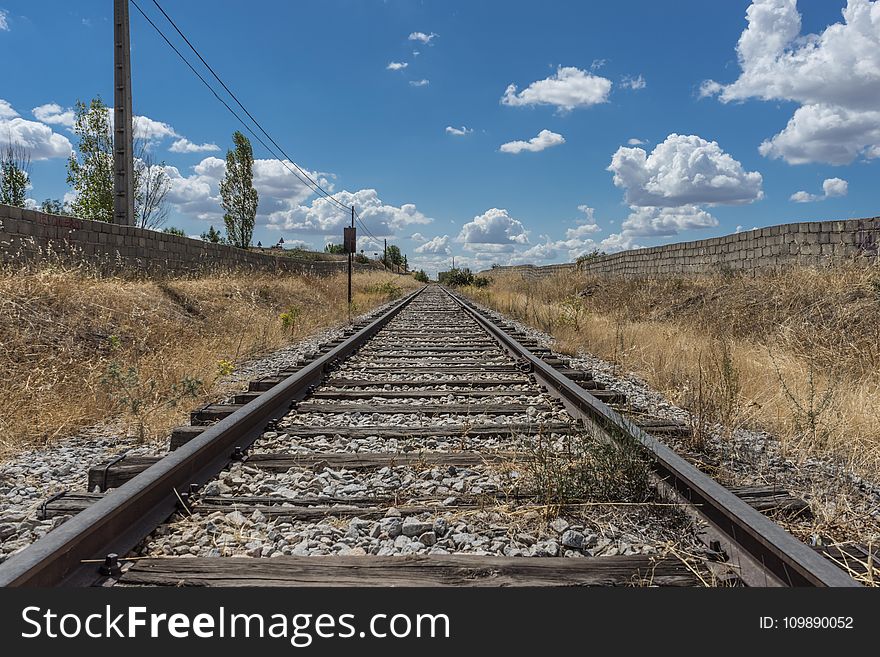 Railroad Track Amidst Trees Against Sky