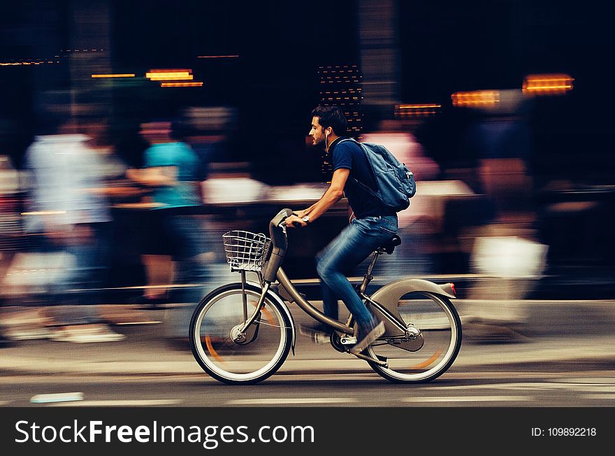 Man Riding Bicycle on City Street