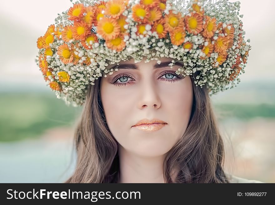 Woman Using White and Orange Floral Hat