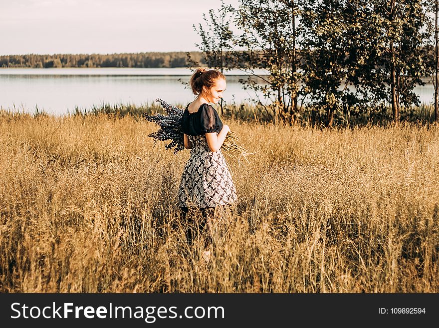 Woman Wears Black and Grey Dress Stands in Field