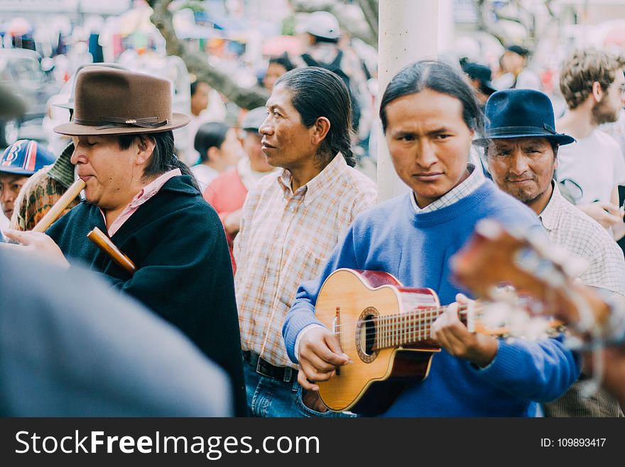 Man Playing Acoustic Guitar Beside People during Daytime