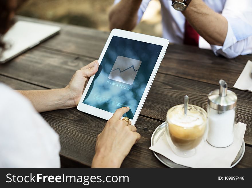 White Tablet Computer On Brown Wooden Table