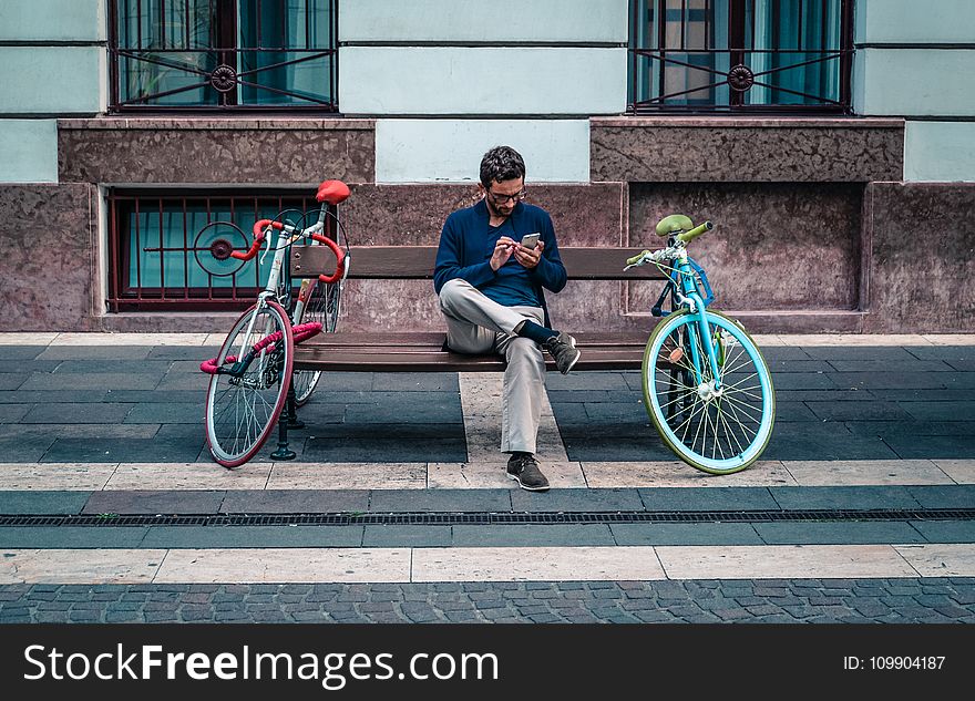 Person Sitting On Bench Between Two Road Bikes