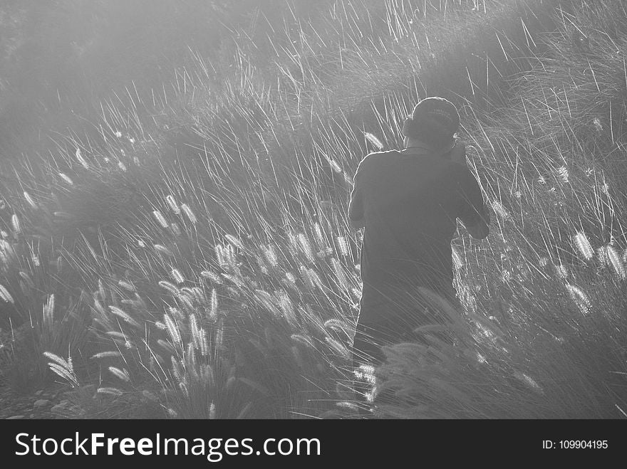 Man Taking Photo on Grass Field in Greyscale Photography