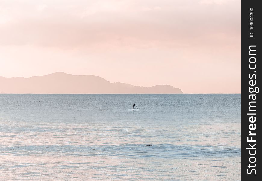 Man Rowing a Boat on Sea at Daytime