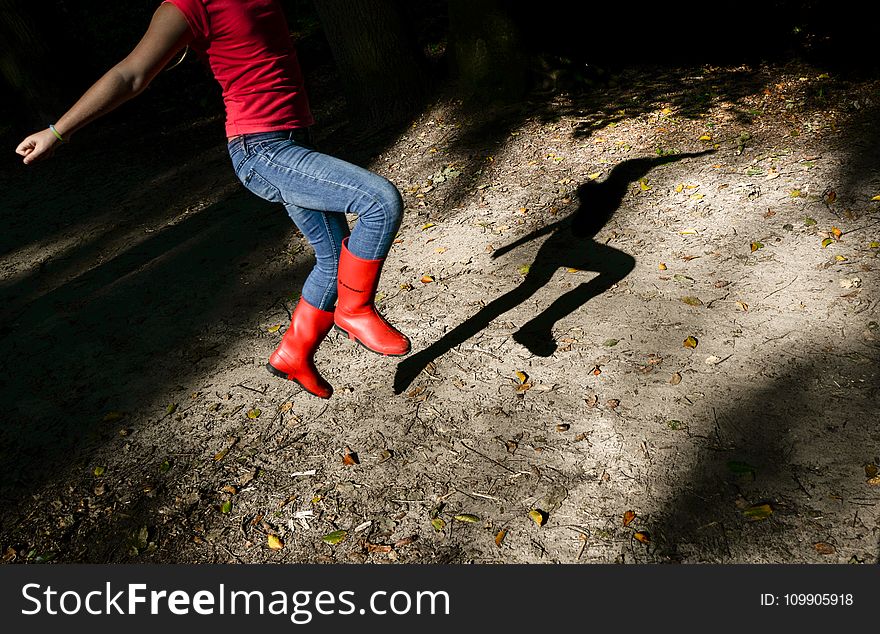 Photography Of A Girl In Red Shirt With Blue Denim Jeans And Red Leather Wide-calf Boots Jumping