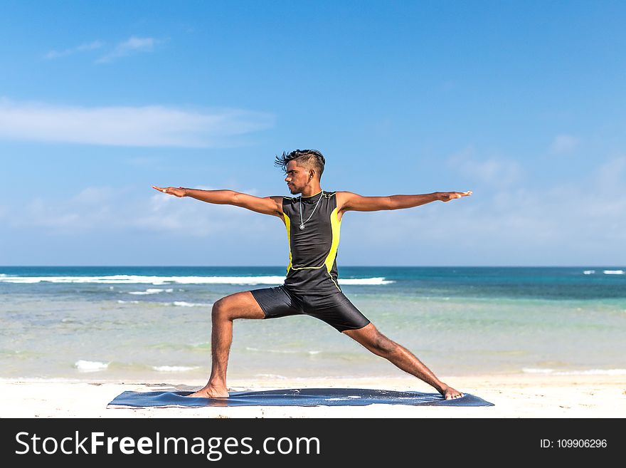 Man in Sleeveless Wet Suit Doing Some Aerobics at the Beach