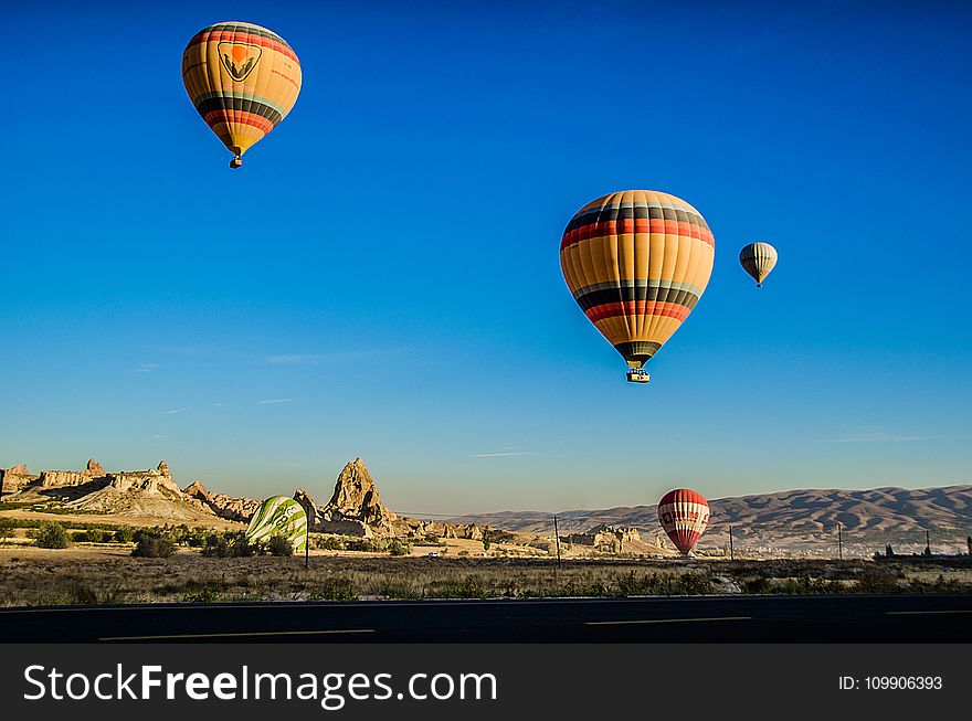 Four Beige Hot Air Balloons Flying