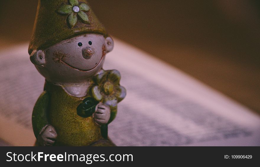 Closeup Photo of Boy Holding Flower Figurine