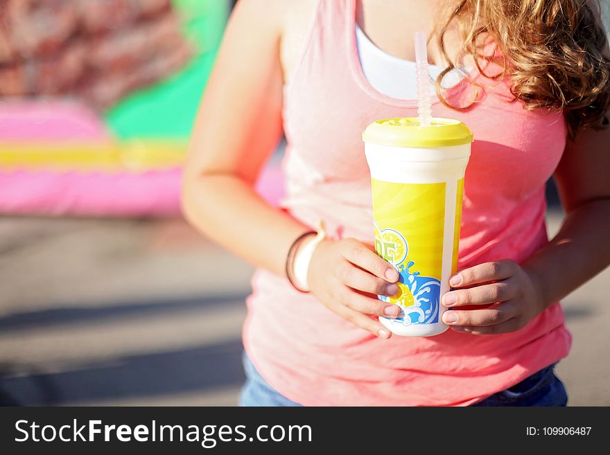 Woman Wearing Pink Tank Top Holding A Tumbler