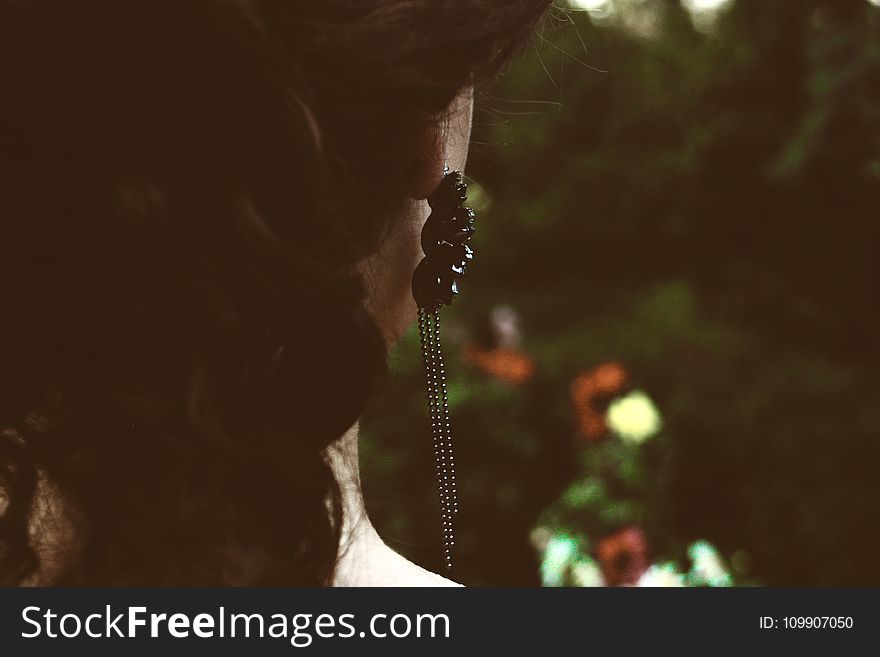 Selective Focus Photography of Woman&#x27;s Back With Black Pendant Earrings